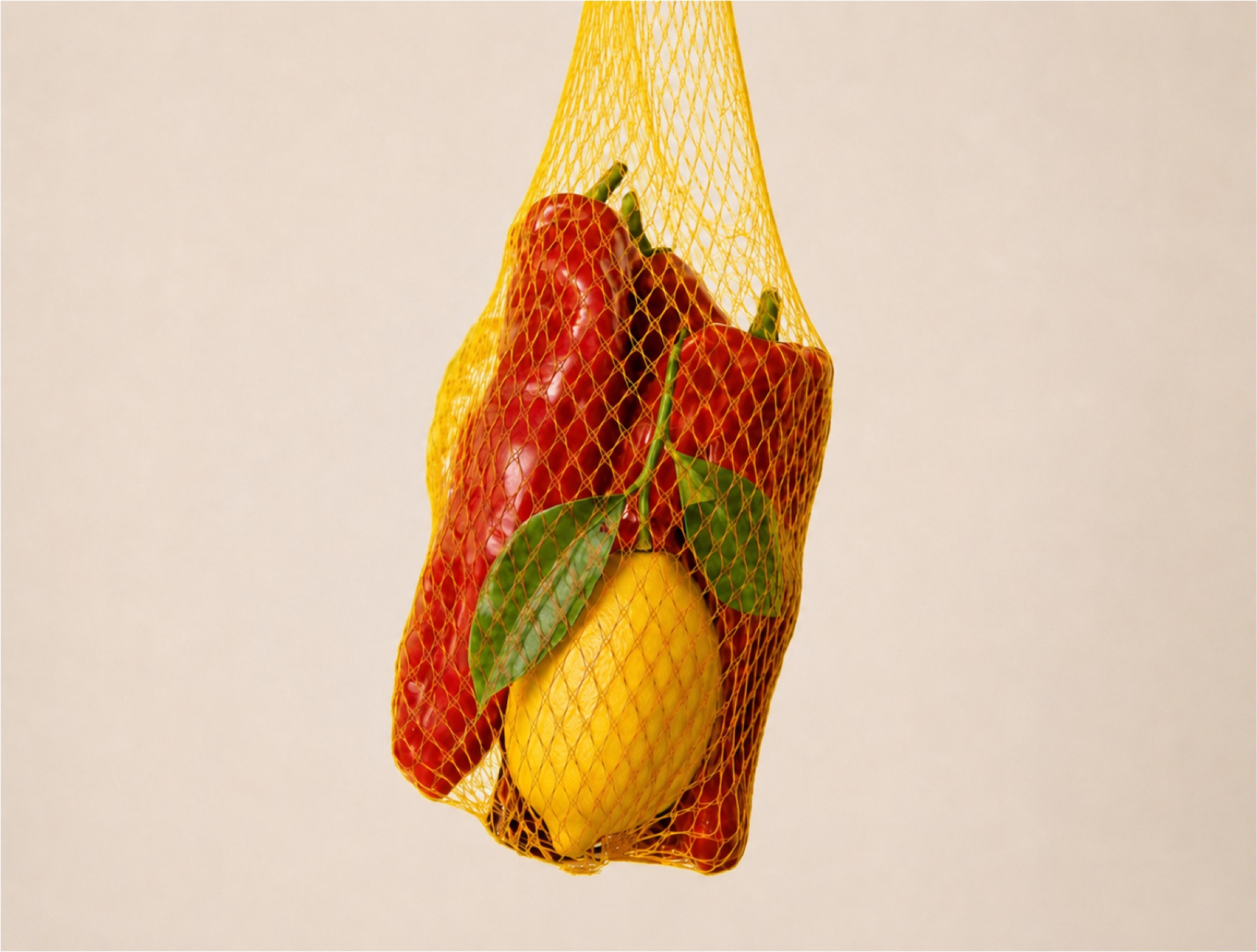 Paprika und Zitrone in einem gelben Obstnetz